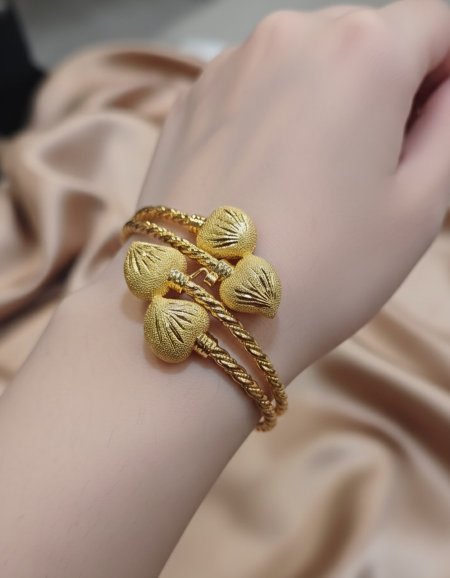 ​سوار أسلاك ذهبية مجدولة بتعليقات قلوب منقوشة